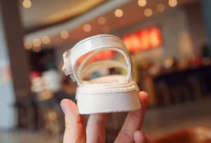 Close-up detail of the white platform sole and heel strap of a girl's sandal