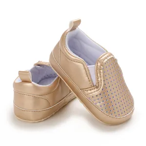 Close-up of golden PU leather baby walking shoes with breathable perforated toe
