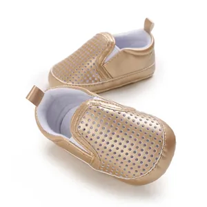 Detail macro view of golden PU leather baby toddler shoes with perforated design