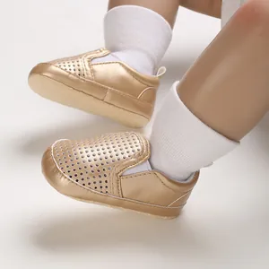 Close-up detail of metallic gold hollow-out PU leather infant pre-walker shoes with soft soles