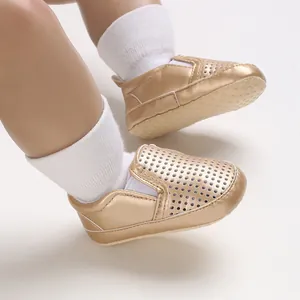 Close-up of golden breathable infant pre-walker shoes with perforated design
