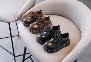 Gedetailleerd overzicht van stijlvolle zwart-bruine leren schoenen in Britse stijl voor jongens
