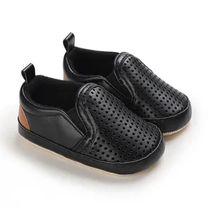 Detailed view of black PU leather baby shoes with breathable hollow-out design and soft sole
