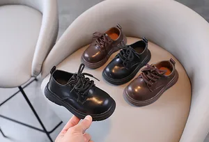 Detailoverzicht van kinderschoenen in Britse stijl in de kleuren zwart en donkerbruin