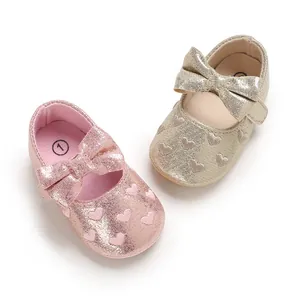 Close-up of glittery baby girl princess walking shoes with cute bows and heart patterns