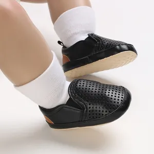 Close-up of black breathable baby walking shoes with perforated leather detail.