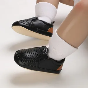 Close-up macro view of black PU leather baby shoes with breathable perforated design