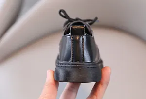 Gedetailleerde close-up van de hiel en dikke rubberen zool van zwarte leren kinderschoenen
