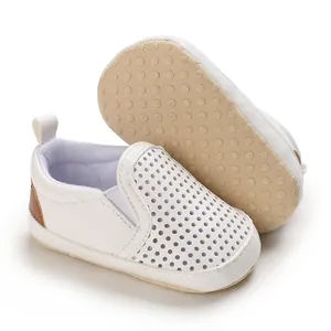 Detailed view of white perforated PU leather infant walking shoes with soft soles