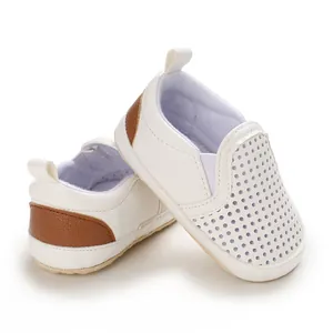 Close-up of white PU leather infant walking shoes with breathable perforated design