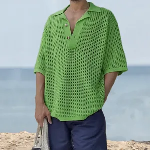 Detailed view of a stylish green crochet knit polo shirt for men in a breezy beach setting.