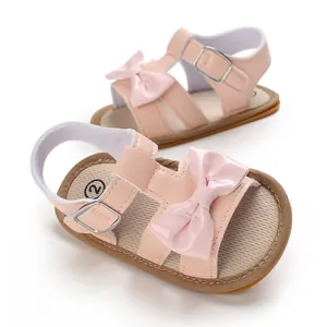 Detailed view of pink baby girl summer sandals featuring cute decorative bow and rubber sole