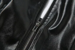 Primer plano de cremallera metálica en un top corto de cuero sintético negro