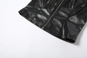 Detalle de cerca de un chaleco de cuero PU negro con cremallera, dobladillo y costuras.