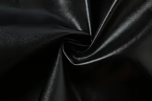 Primer plano de tela de cuero PU negro que muestra grano fino y textura suave.