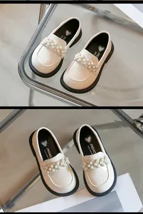 Close-up detail of girls' beige loafers featuring elegant pearl and rhinestone embellishments