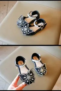 Gros plan de chaussures Mary Janes noires pour filles avec papillon en strass et perles