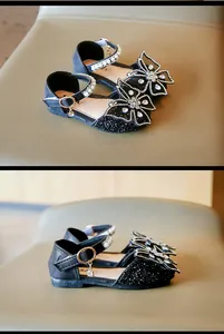 Détail de chaussures de princesse noires pour filles avec nœud en strass et perles