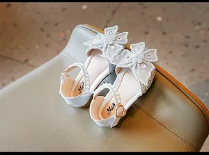 Détail de chaussures de princesse argentées pour filles avec fleurs en résille et perles
