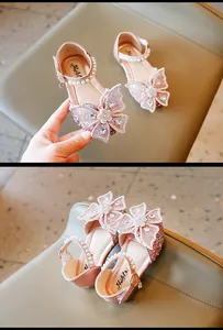 Gros plan sur des chaussures de princesse roses à paillettes avec nœud papillon et perles