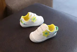 Zapatos de malla blanca para bebé con flor amarilla y suela blanda antideslizante.