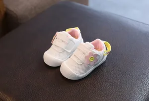 Vista detallada de zapatos de malla blanca para bebé niña con un adorno de flor rosa