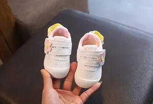 Zapatos de malla blanca para bebé con detalle de flor rosa y correa amarilla