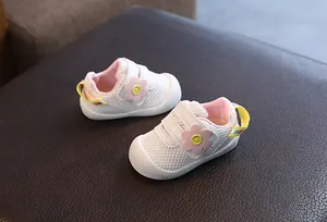 Vista detallada de zapatos de malla blanca para bebé con parche de flores rosas