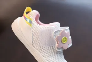 Vista detallada de zapatos de malla blanca transpirable para bebé niña con flor rosa