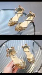 Dettaglio delle paillettes dorate scintillanti e dell'elegante fiocco sulle scarpe da bimba