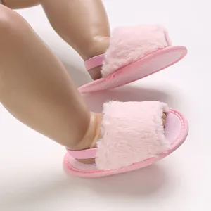 Close-up view of pink fuzzy baby sandals with elastic backstrap shown on a doll model