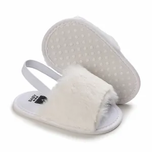 Detailed view of white faux fur baby sandals featuring non-slip dotted soles for infants