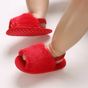 Detailed macro view of red furry baby girl sandals featuring non-slip silicone soles