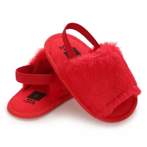 Detailed view of red fuzzy baby sandals with elastic back strap and textured sole