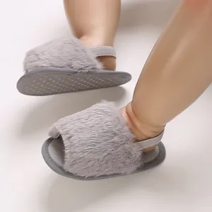 Detail view of grey fluffy baby sandals with anti-slip silicone soles for infant girls