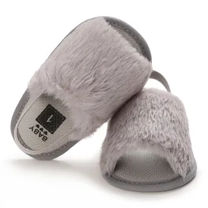 Detailed view of grey fuzzy baby sandals with secure elastic heel strap