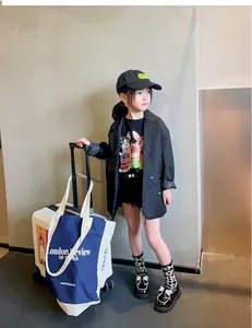 Niña elegante con mocasines de charol negro y lazos de diamantes brillantes en un atuendo de moda