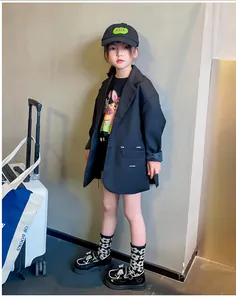 Imagen de cuerpo entero de una niña con mocasines negros brillantes con un lazo