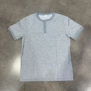 Detailed view of grey short-sleeved Henley shirt featuring a buttoned round neckline