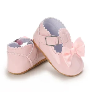 Detail of pink bow baby princess shoes with shiny patent finish and soft soles