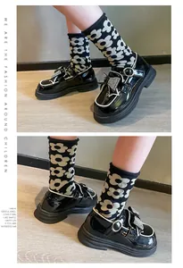 Primer plano de zapatos de charol negro para niña con lazo de diamantes y estilo inglés