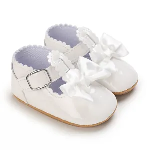 Elegant white patent leather baby girl shoes with ribbon bow and T-strap detail