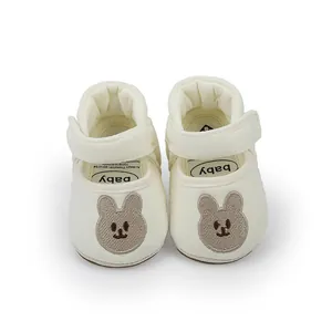 Detailed view of cream baby pre-walker shoes with cute bear embroidery and hook-loop strap