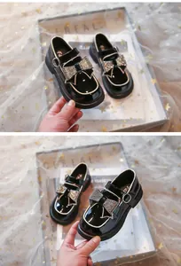 Vista detallada de zapatos de charol negro para niña con un lazo de diamantes de imitación