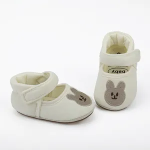 Detail view of cream infant walking shoes with cute bear embroidery and velcro strap