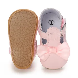 Detail showing pink baby girl princess shoes with decorative silk bow and soft non-slip sole