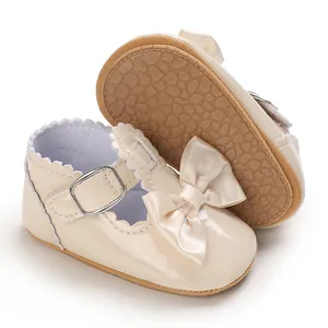 Close-up of beige baby princess shoes with satin bow and non-slip soft sole for toddlers.