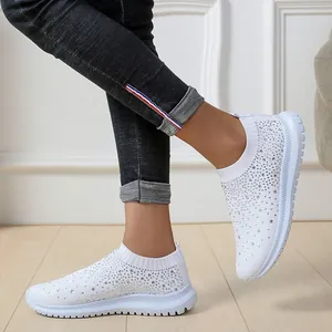 Weiße Sneaker mit Strasssteinen und Fly-Knit-Gewebe in gemütlicher häuslicher Umgebung.