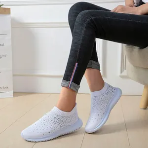 Detail der weißen atmungsaktiven Fly-Knit-Sneaker mit funkelndem Strassbesatz