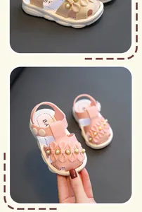 Nahaufnahme von rosa und beigen Babysandalen mit Schmetterlings- und Perlendekor